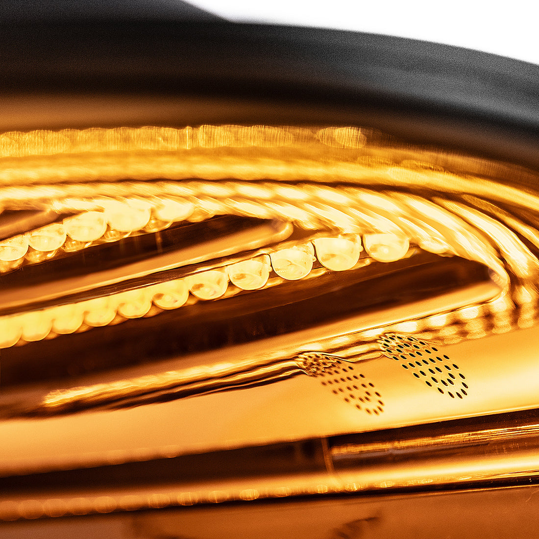 Amber LED array raking across black anodised metal